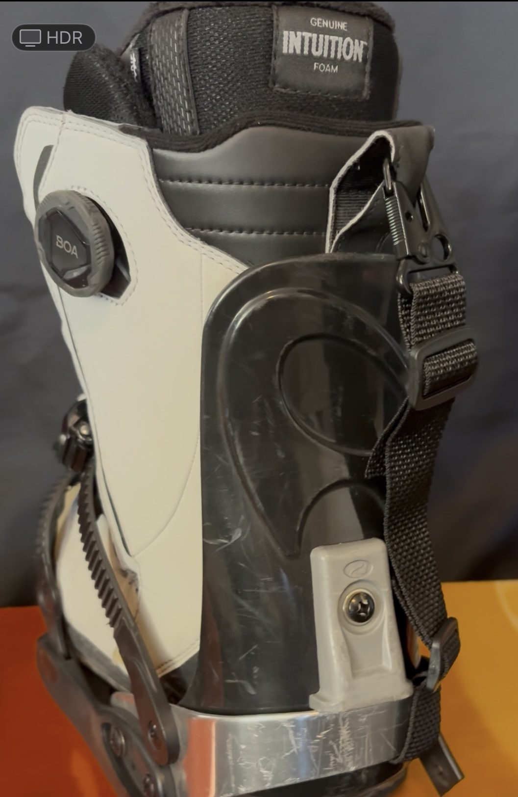 Close-up of a white and black motorcycle boot with buckles and protective features.